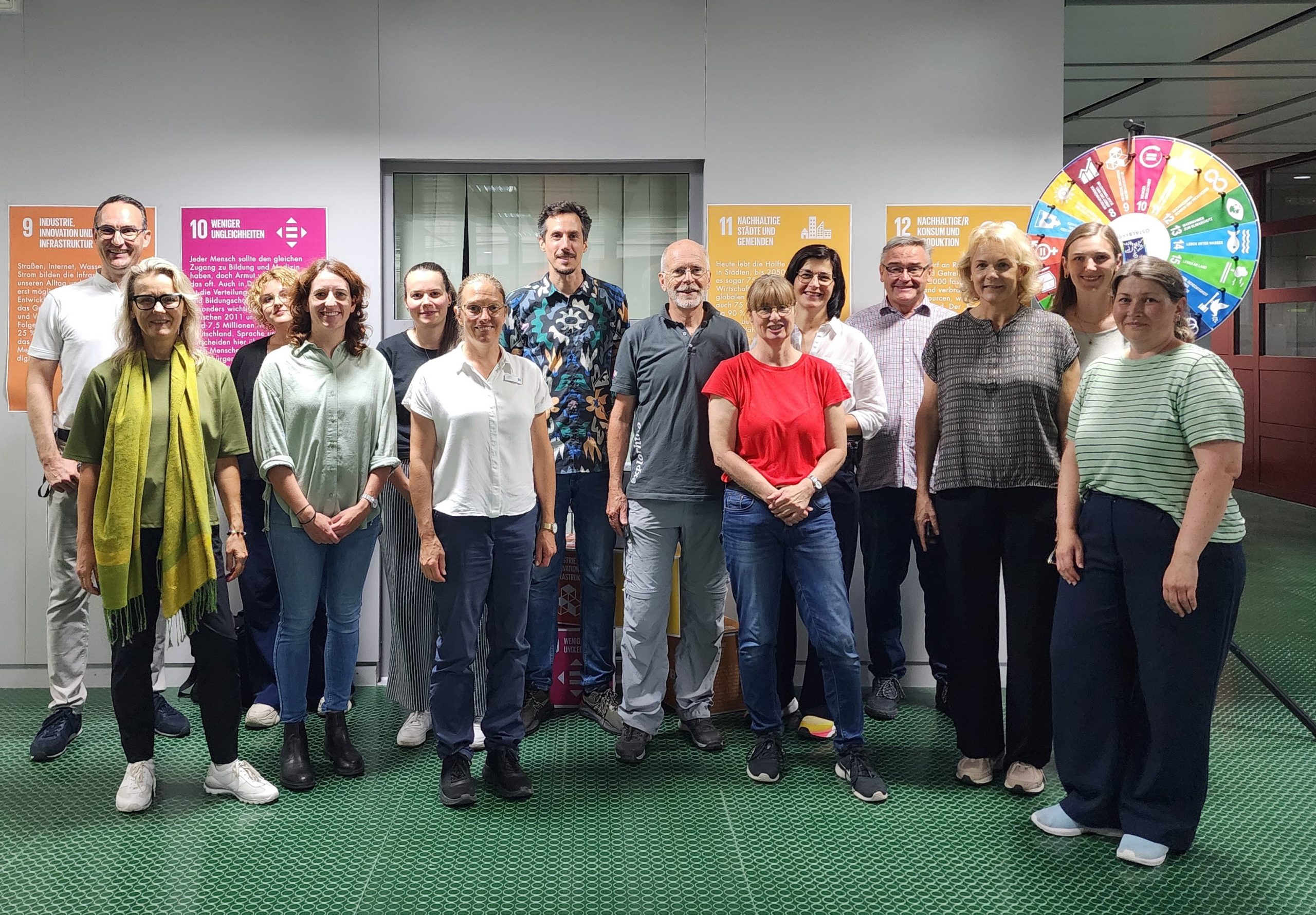 Gruppenfoto beim BNE-Marktplatz am KBSZ Aalen vor Tafeln zu den UN-Nachhaltigkeitszielen.